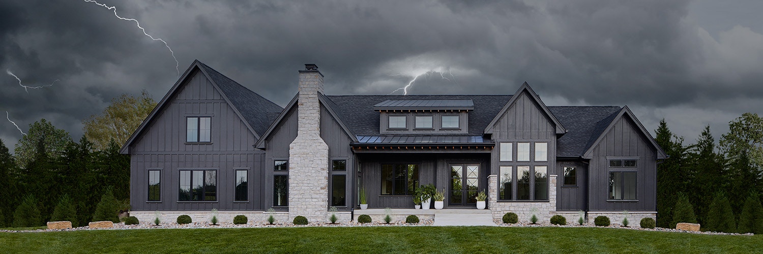 contemporary home featuring impervia windows in a storm lightning behind the house