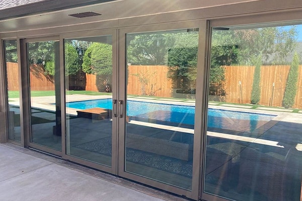 four-panel french sliding patio door reflecting a swimming pool