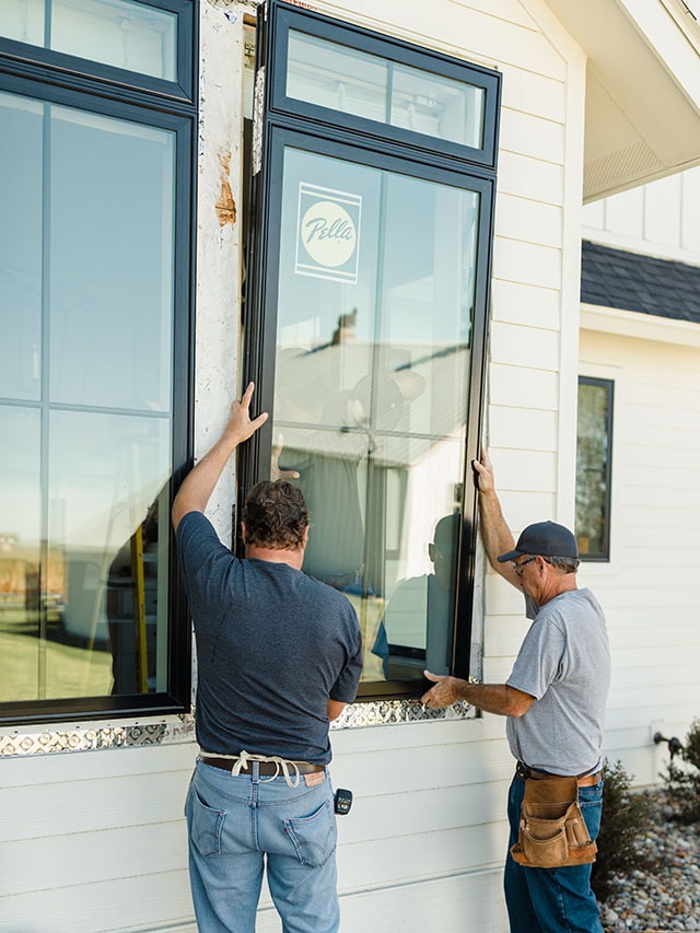 Professional installation of a Pella window on a home exterior.