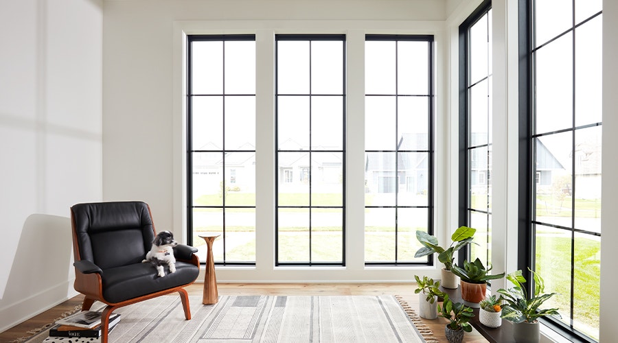 three casement windows with transoms and blinds-between-the-glass in a beige-colored living room.