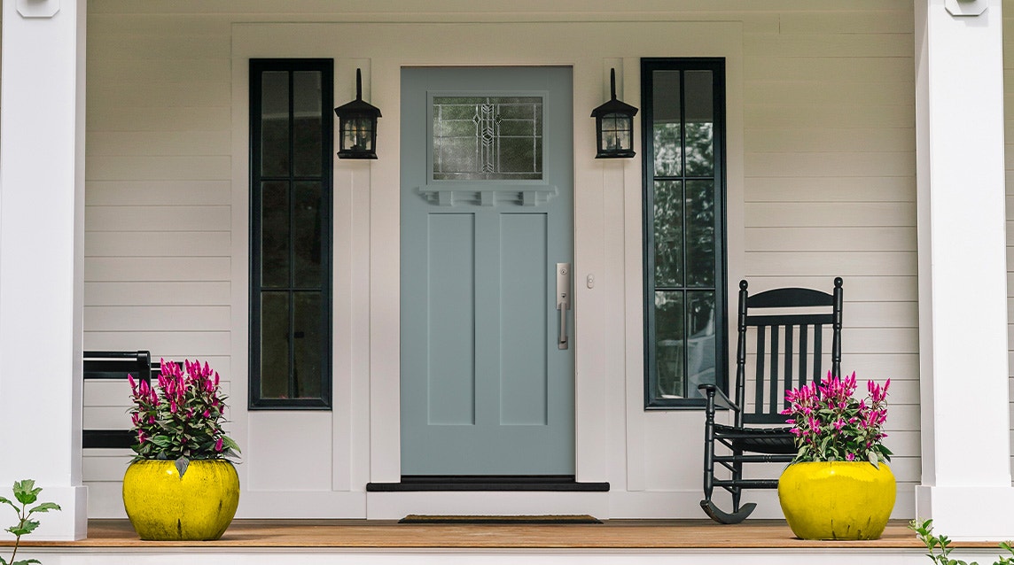 Frost blue entry door of white craftsman style home