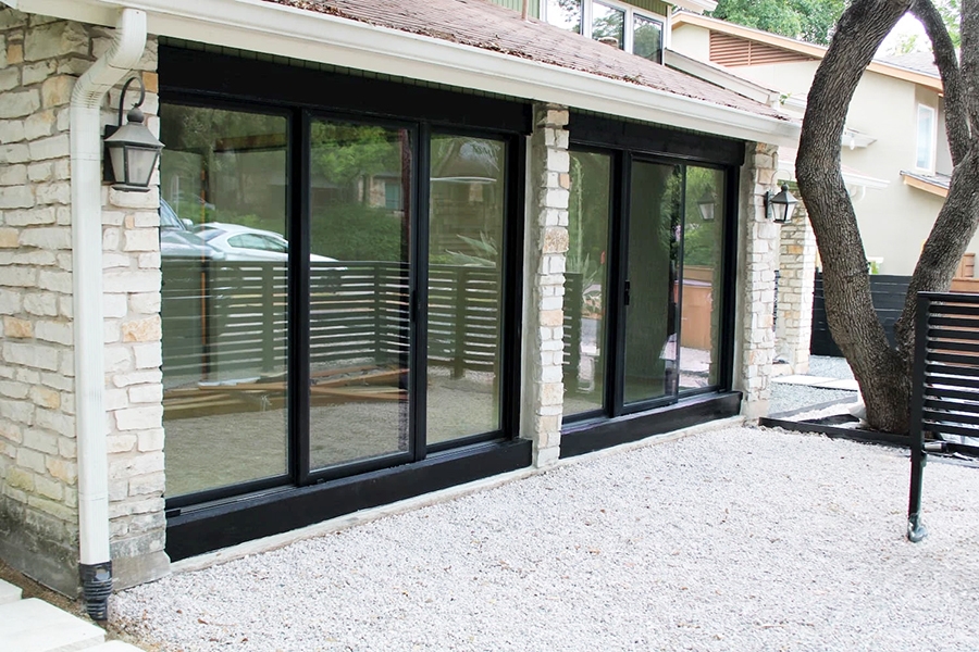 Exterior view of newly installed Pella triple sliding glass doors for an Austin garage.