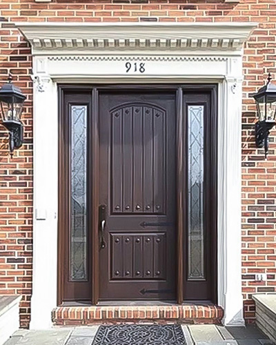 A brick home with an updated fiberglass front door and full light sidelights with decorative glass.