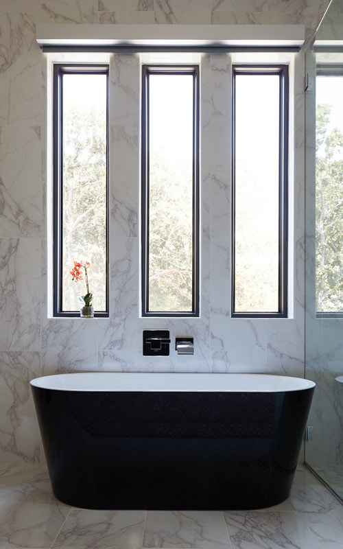 Marble bathroom with black tub and waterproof windows