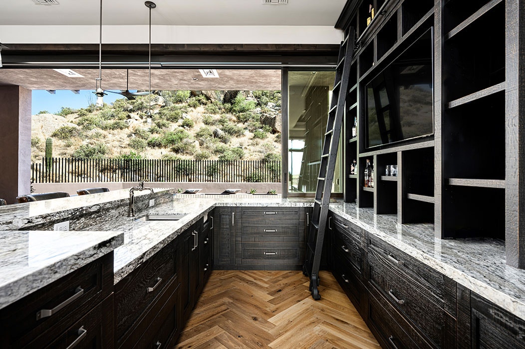 Interior of a Scottsdale modern home kitchen with open modern sliding patio door highlighting the desert landscape.
