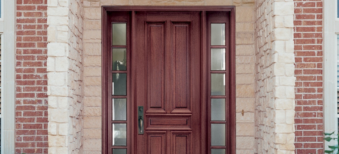 four panel traditional wood entry door with full light sidelights on each side