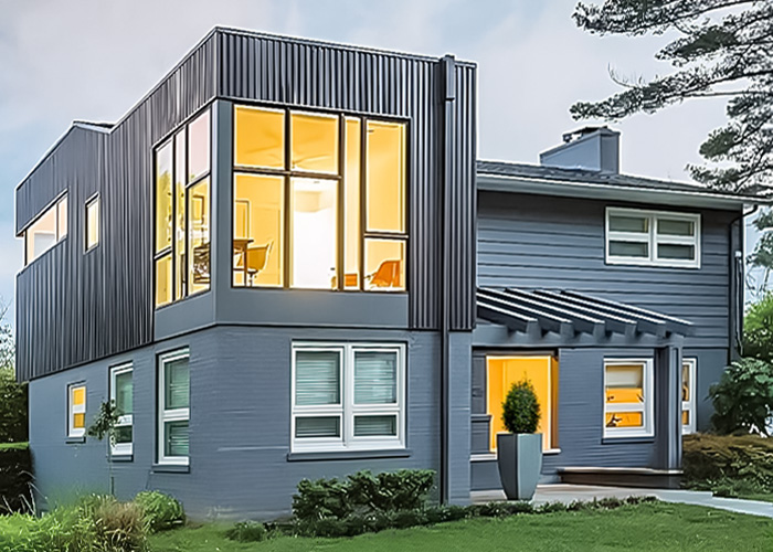 Modern second story addition with walls of black windows on gray traditional home