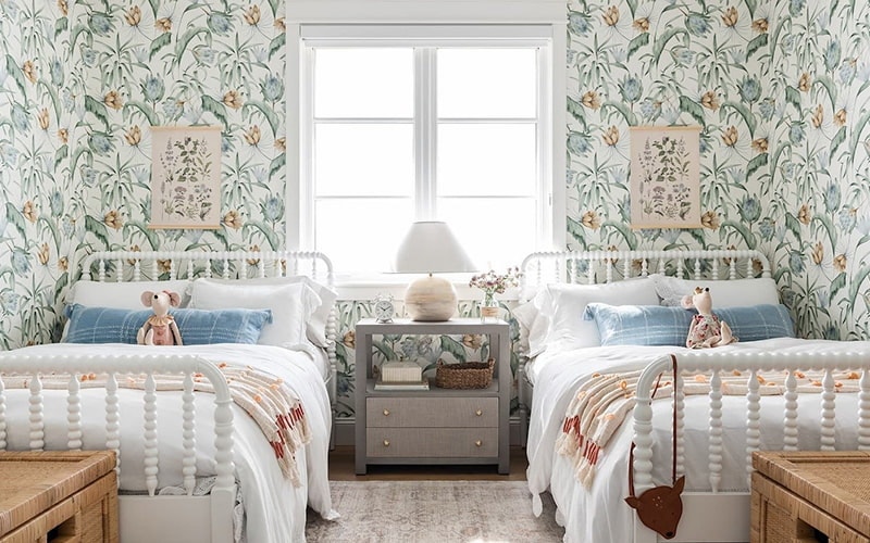 child's bedroom with two white casement windows in between and colorful wallpaper