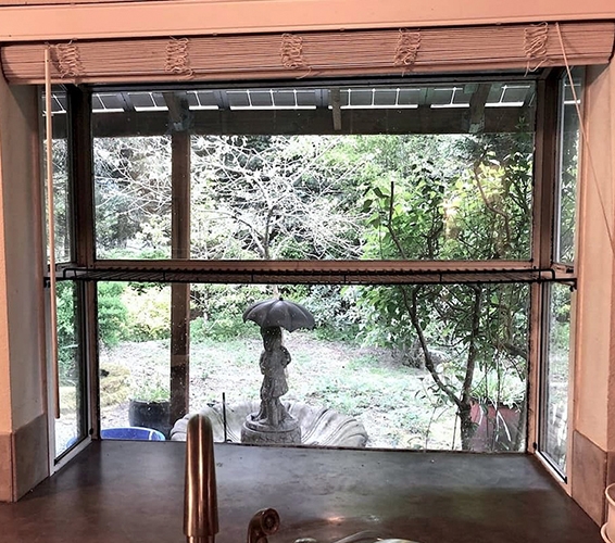 An old, outdated window box sits behind a kitchen faucet surrounded by an orange-hued paint