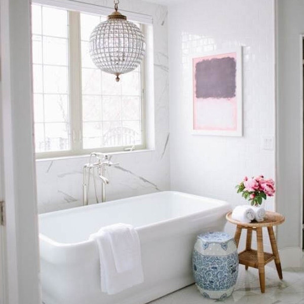 White casement windows with traditional grille patterns over a tub in a bump-out in a white bathroom.