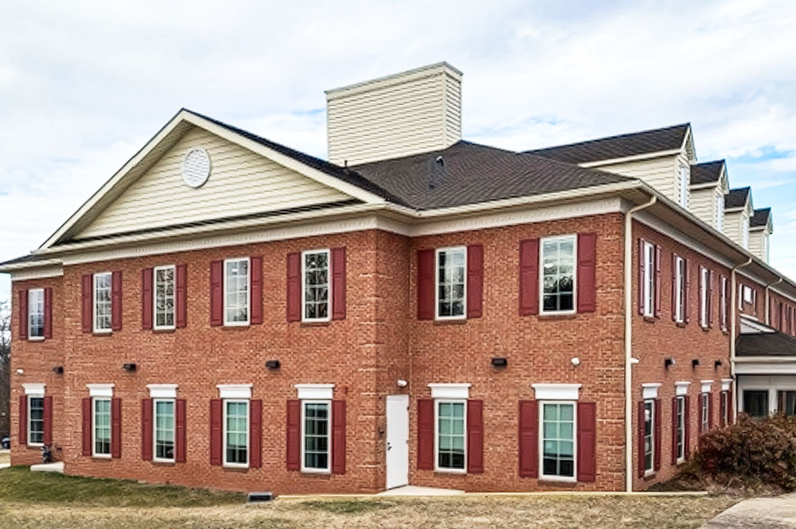Side angle of a brick commercial building in Pottstown, Pennsylvania showcasing upgraded Pella commercial windows.