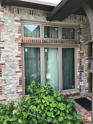 three replacement casement windows with awnings over each, on a brick and stone Tulsa home