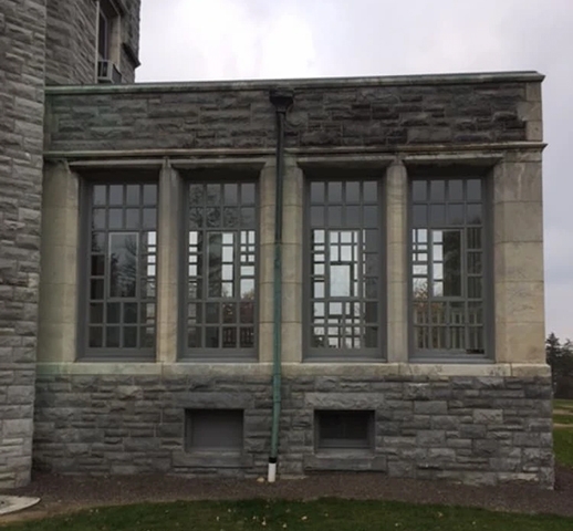 Side of Glamorgan Castle with outdated windows.