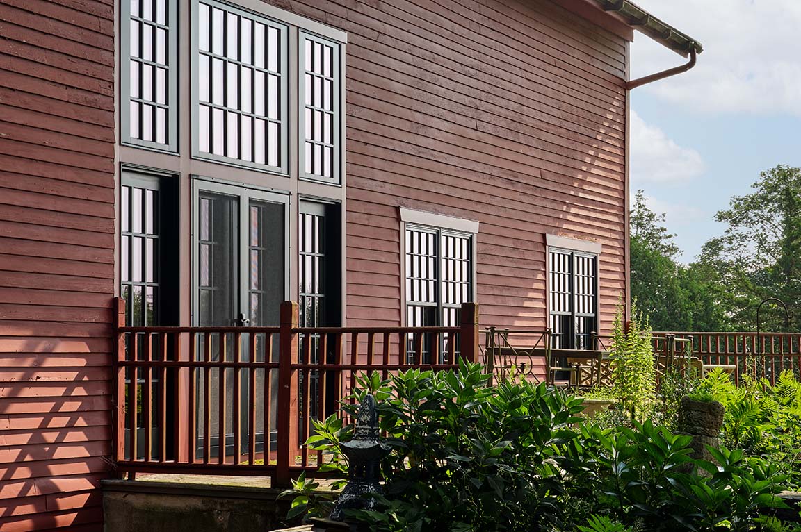 Traditional double black french doors in a large dining room with black and white tile flooring