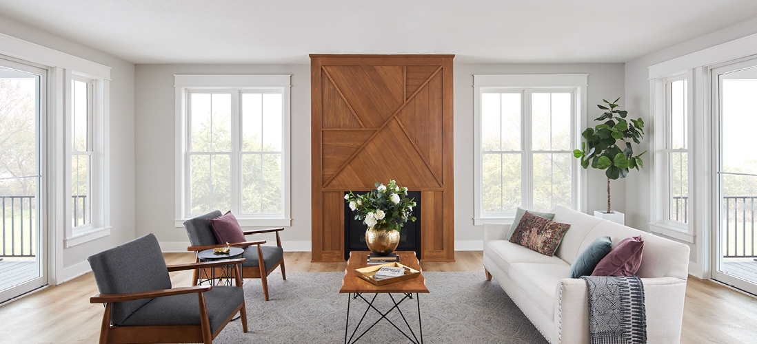 white encompass windows in a white living room with wood fireplace
