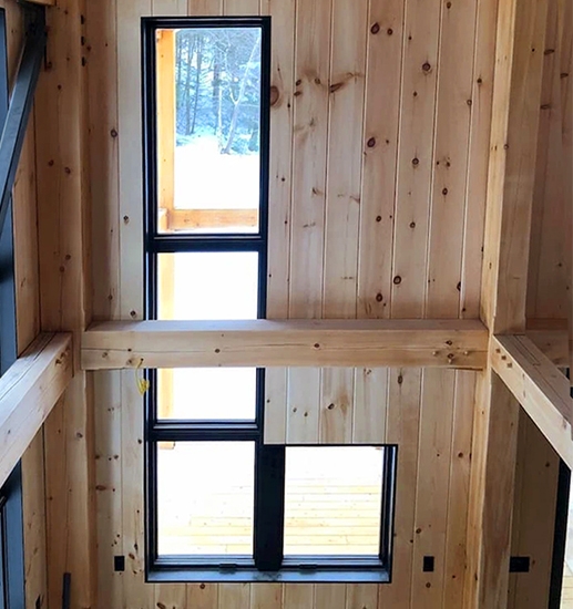 Interior photo of Hinesburg cabin with newly installed black windows. 