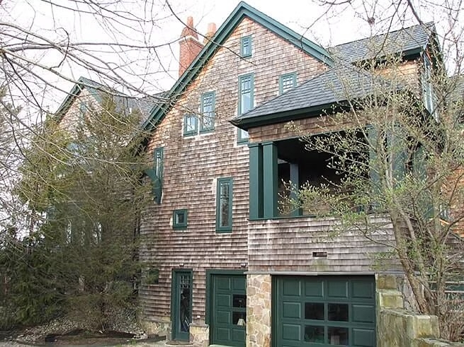 a wood-shingled home in Rhode Island with custom green windows and doors