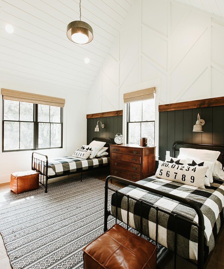 A farmhouse-style bedroom has two twin-size beds and black double-hung windows.