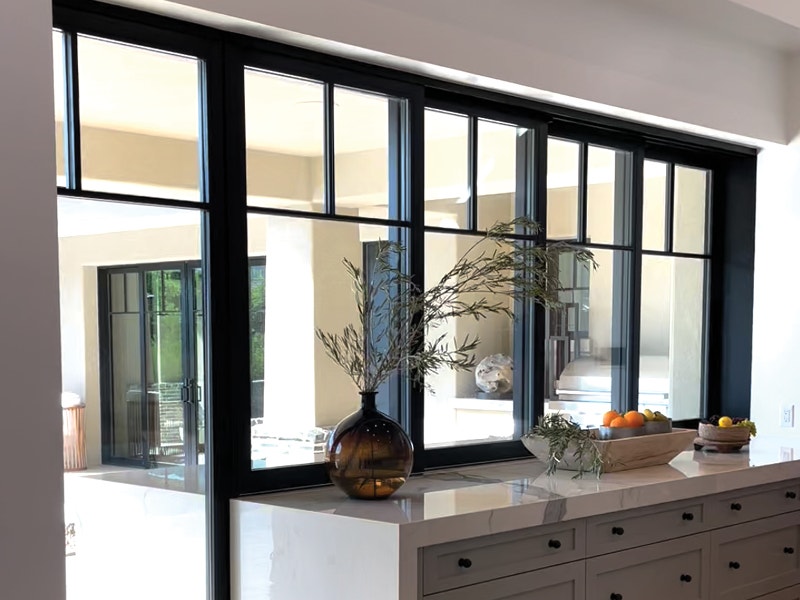Black sliding patio doors with window grilles closed in the kitchen