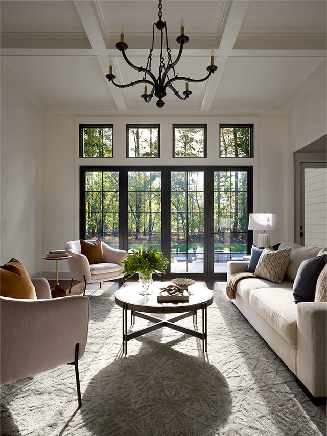 The view of a black four-panel patio door with grilles-between-the-glass on the far side of a long living room.