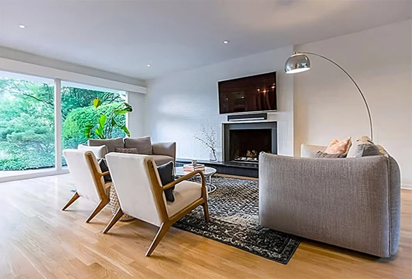 Modern living room is full of natural light from two wall sized fixed windows