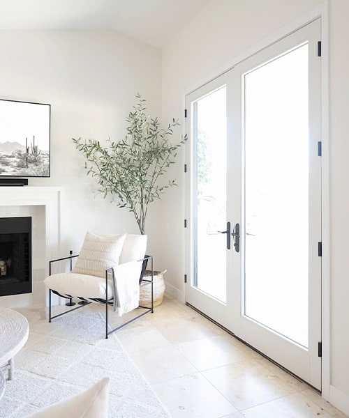 a contemporary chair in front of a potted tree next to a set of white french doors