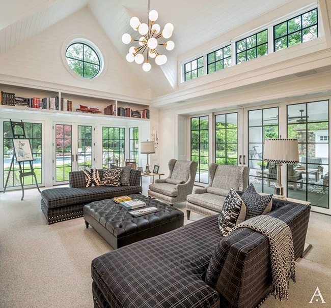 Modern sunroom with black stained French doors, casement windows and varying window shapes.