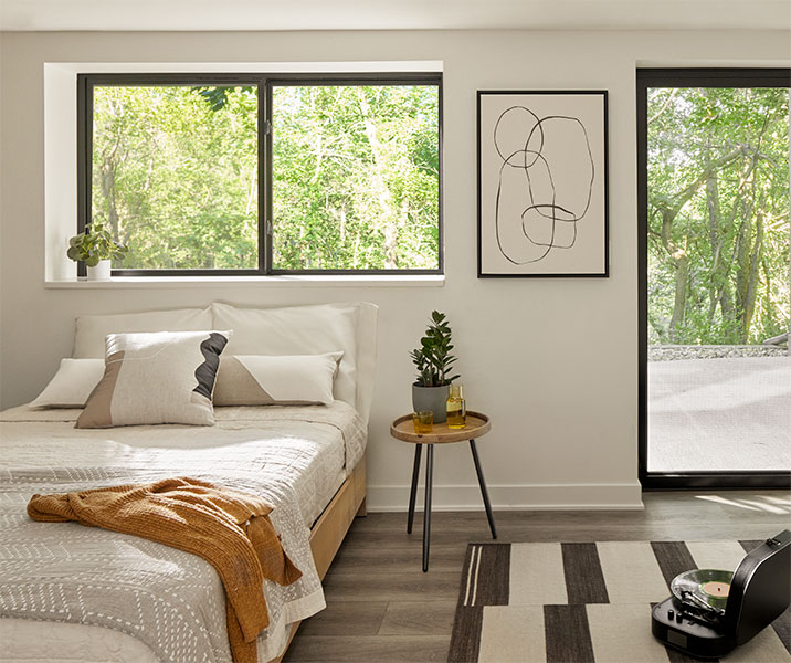 A simple kitchen counter is surrounded on each wall with black sliding windows.