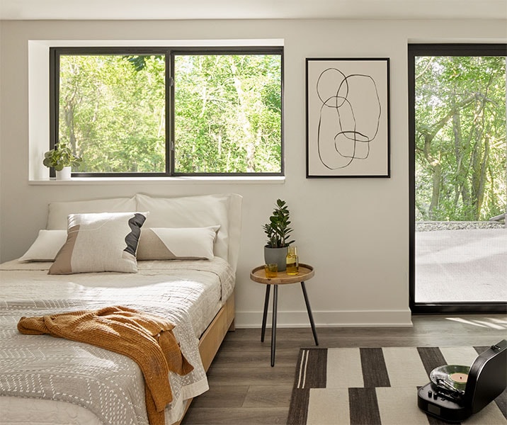 A simple kitchen counter is surrounded on each wall with black sliding windows.