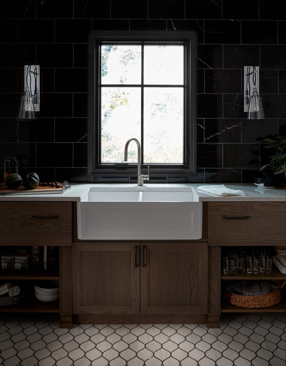 Black casement window with matte black hardware over apron sink and wood cabinets