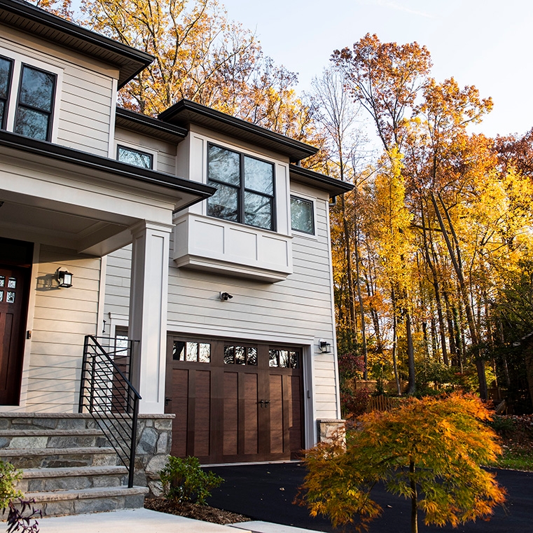 Brown windows on front exterior, surrounded by fall foliage  in Falls Church home. 
