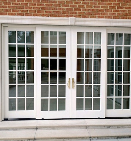Before image of white standard sliding French doors installed in a brick home