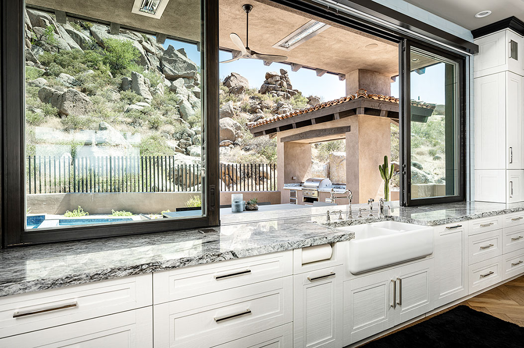 Kitchen pass through window highlighting Scottsdale backyard view.