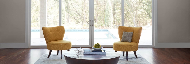 two yellow chairs in front of a pella sliding door