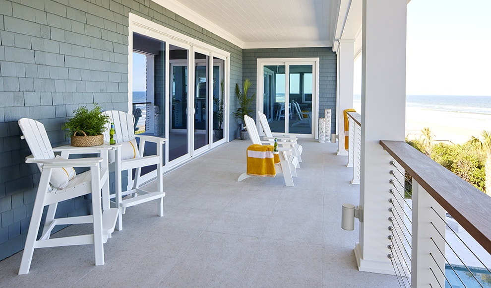 An expansive deck that overlooks the ocean with two sets of sliding patio doors.
