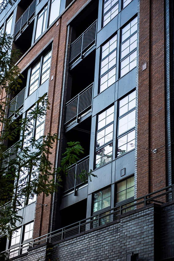 Steel-framed windows on exterior of brick apartment complex in Port Covington. 