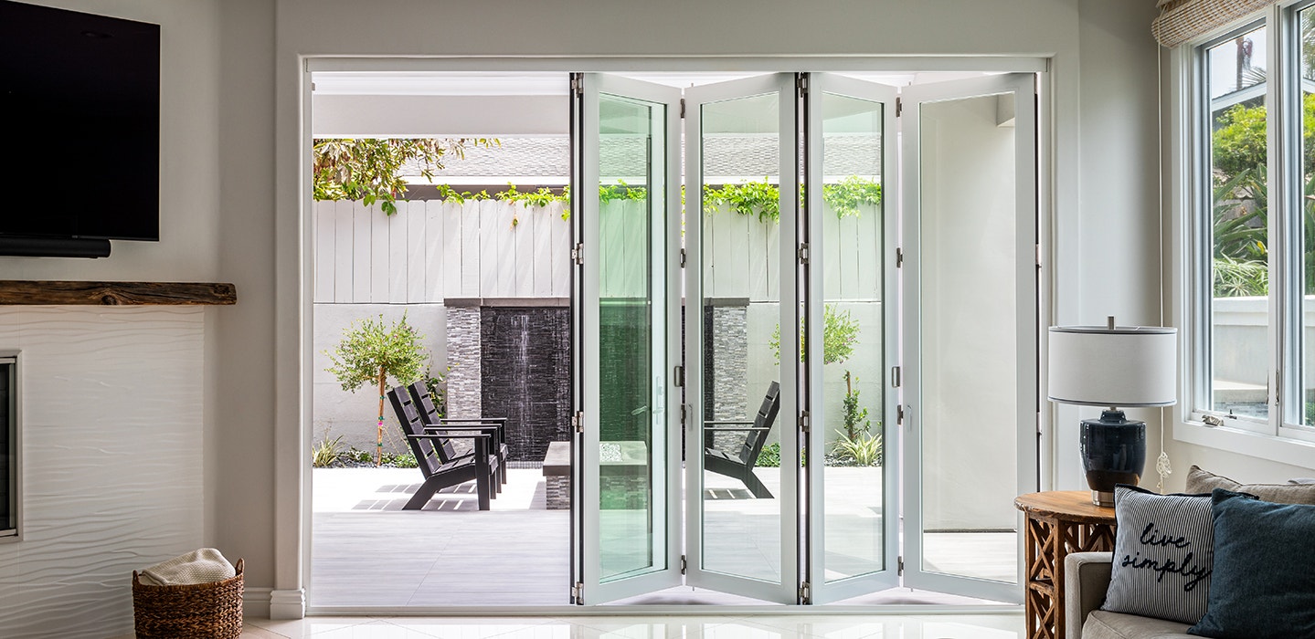 wood-framed bifold patio door in a contemporary living room with concrete floors