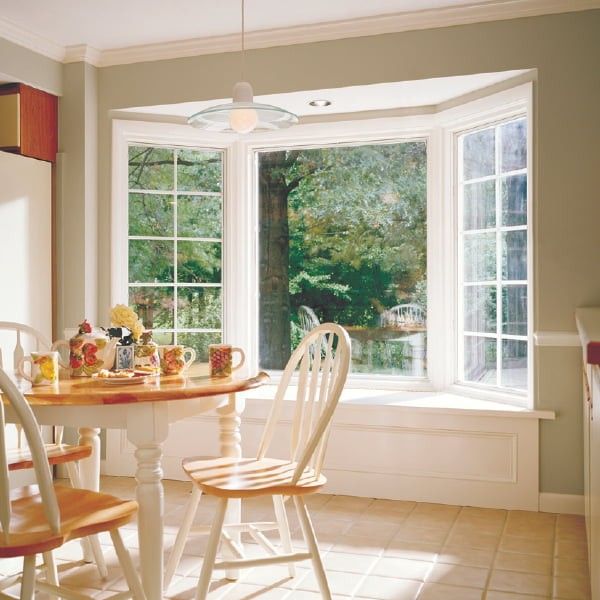 Small dinner table in a breakfast nook with a white bay window