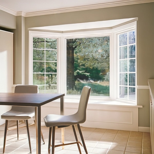 Small dinner table in a breakfast nook with a white bay window