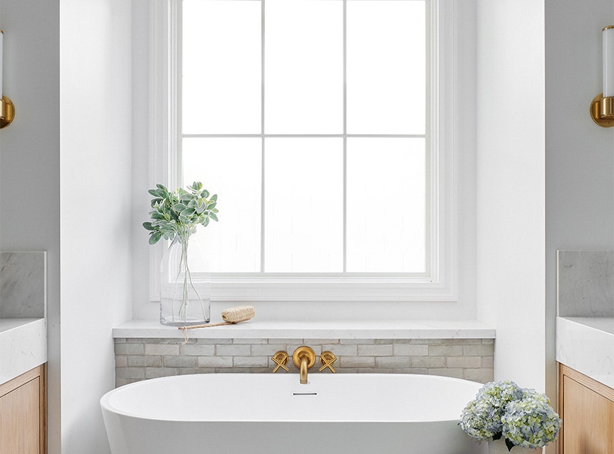 a modern white bathroom with a contemporary soaking tub and a picture window