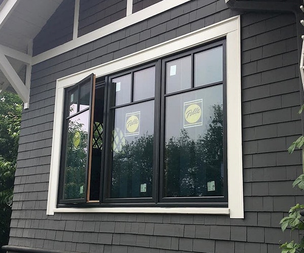 an angled view of three black casement windows, each with a Pella bullseye sticker