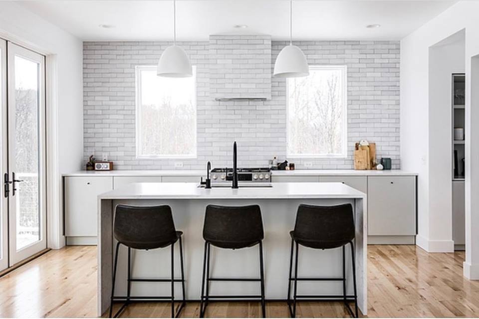 Two white casement windows above kitchen island with black barstools