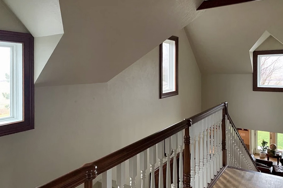 new casement windows with wood trim on the upper floor of an open-concept home.