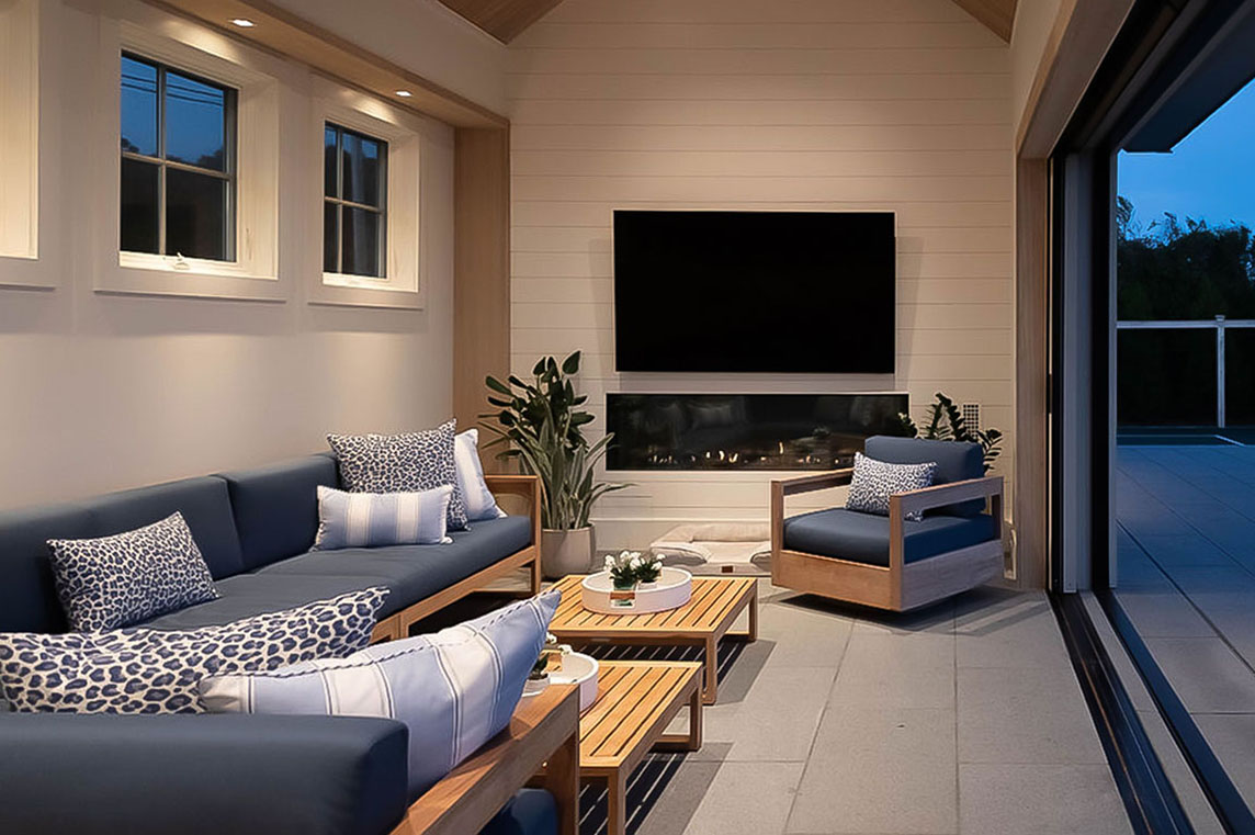 Modern pool house interior with TV, cozy seating, and sliding glass doors
