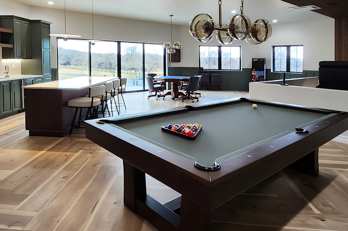 A modern living room featuring a pool table and a black multi slide patio door with Colorado National Monument views.