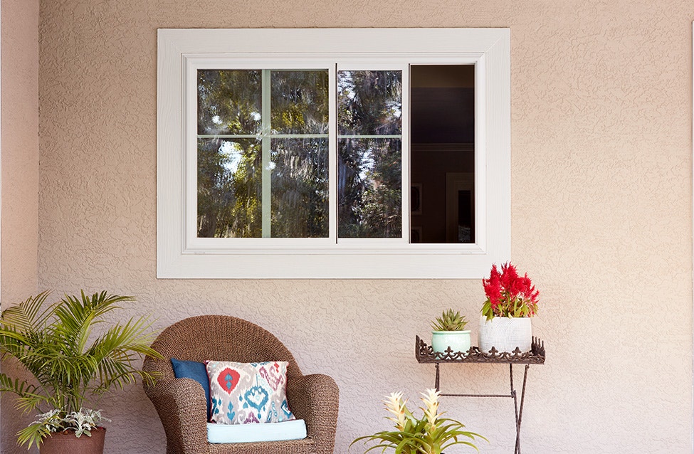 a two-panel sliding window on a pink stucco coastal home