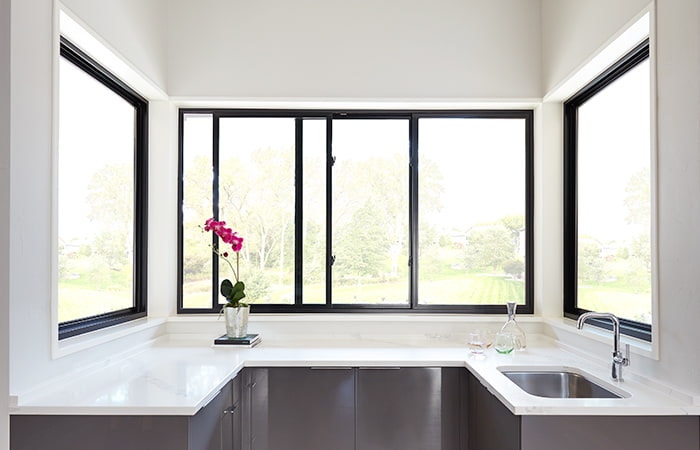 black fiberglass sliding windows above a kitchen counter
