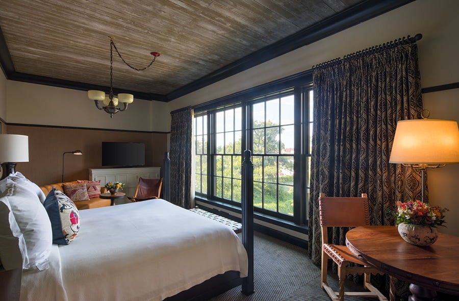 A cozy hotel room with multiple black single-hung windows