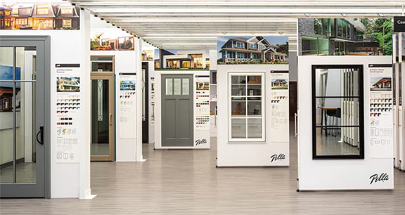 Window and door showroom with rows of display panels showing modern windows, exterior doors, and finish samples