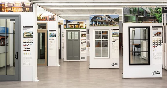 Window and door showroom with rows of display panels showing modern windows, exterior doors, and finish samples